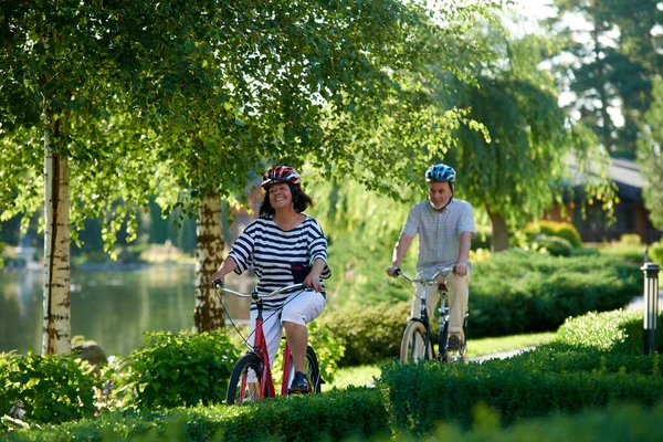 Ώριμο παντρεμένο ζευγάρι κάνει βόλτες με το ποδήλατο. — Φωτογραφία Αρχείου