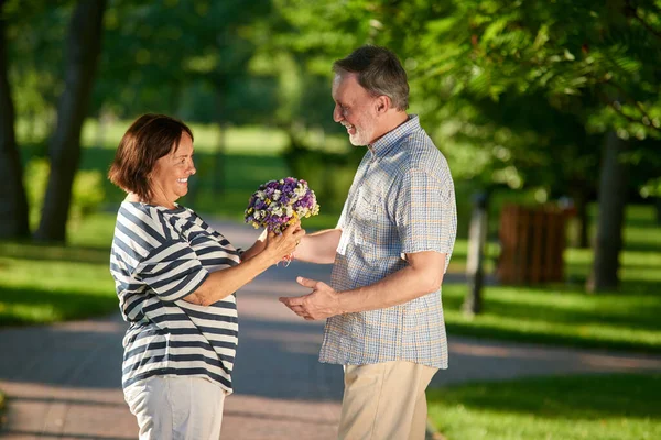 Γυναίκα που δίνει λουλούδια στον άντρα της. — Φωτογραφία Αρχείου