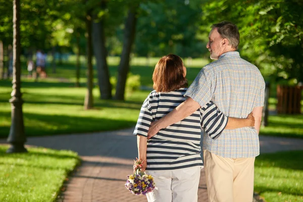 Back view mature couple in the park.