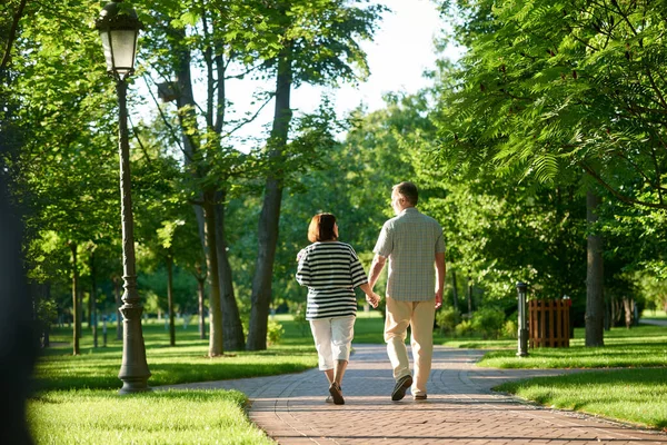 Couple holding hands in the park.