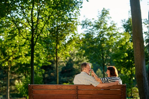 Συνταξιούχο ζευγάρι που διασκεδάζει στο παγκάκι του πάρκου. — Φωτογραφία Αρχείου