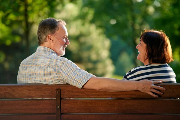 Feliz pareja riendo en el banco. —  Fotos de Stock