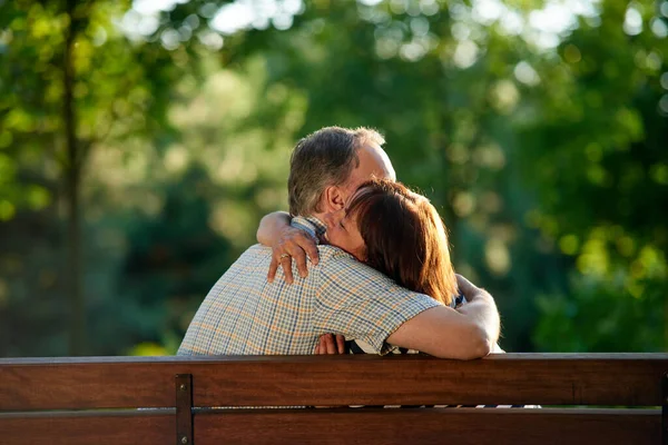 Câlin couple mature sur le banc. — Photo