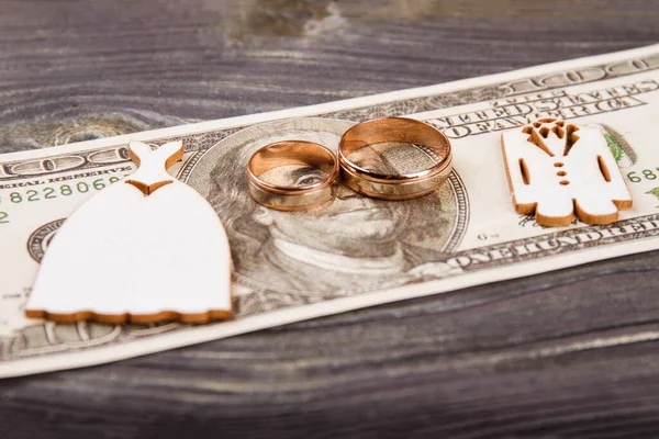 Anéis de casamento nas notas de 100 dólares. — Fotografia de Stock