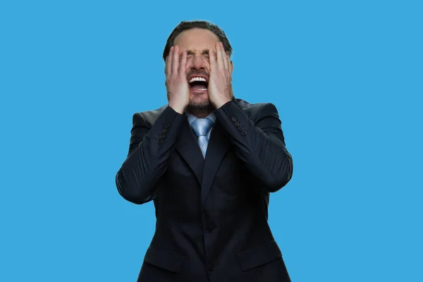 Retrato de empresario llorando aislado sobre fondo azul. — Foto de Stock