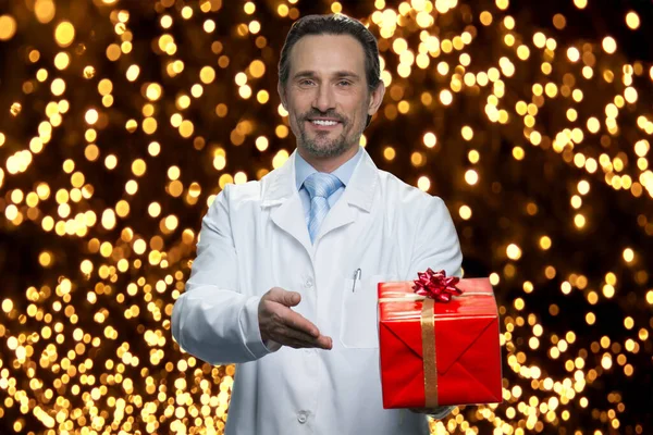 Médicos dando-lhe presente para o Natal. — Fotografia de Stock