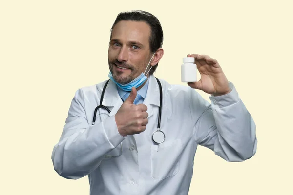 Hombre médico con frasco de medicamentos muestra el pulgar hacia arriba. — Foto de Stock