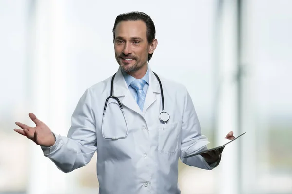 Starší mužský lékař s tabletou pc podává prezentaci. — Stock fotografie