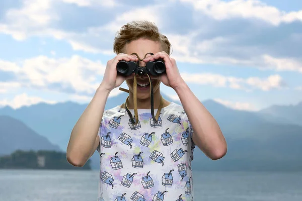 Portrait of teen boy looks through binoculars. — Stock Photo, Image