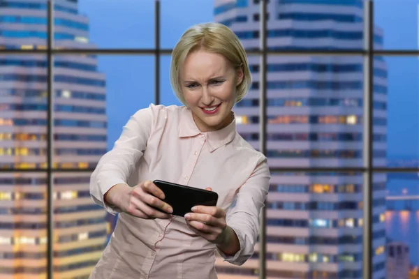 Mature womans playing game on her smartphone. — Stock Photo, Image