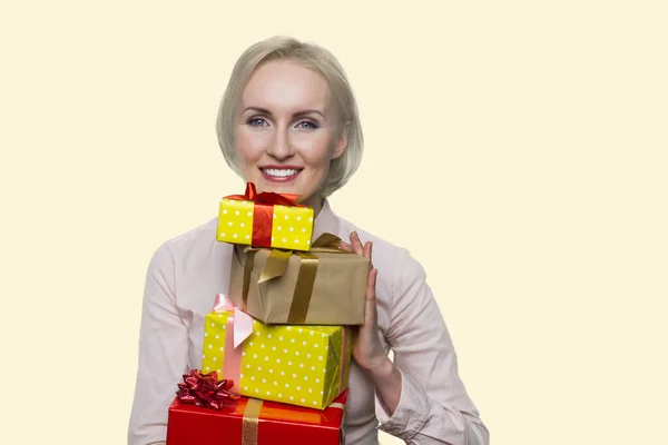 Mulher americana alegre está segurando muitas caixas de presente. — Fotografia de Stock