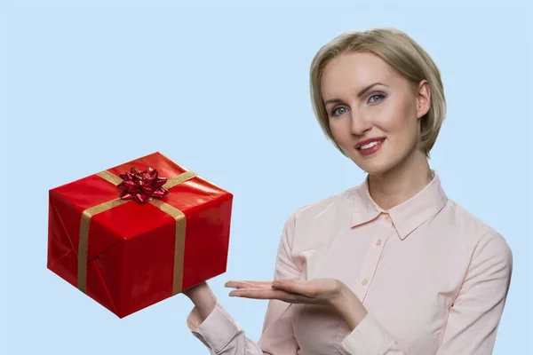 Портрет зрелой женщины показывает красную подарочную коробку. — стоковое фото