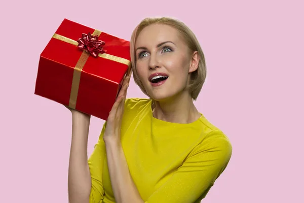 Donna matura ascoltando scatola regalo. — Foto Stock