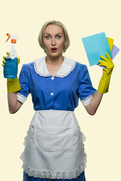 Empregada doméstica espantada com tapetes e detergente. — Fotografia de Stock
