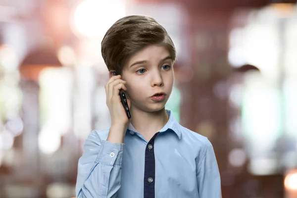 Serieuze kleine jongen praat aan de telefoon. — Stockfoto