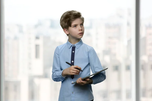 Serious little boy with tablet and pen. — Stock Photo, Image