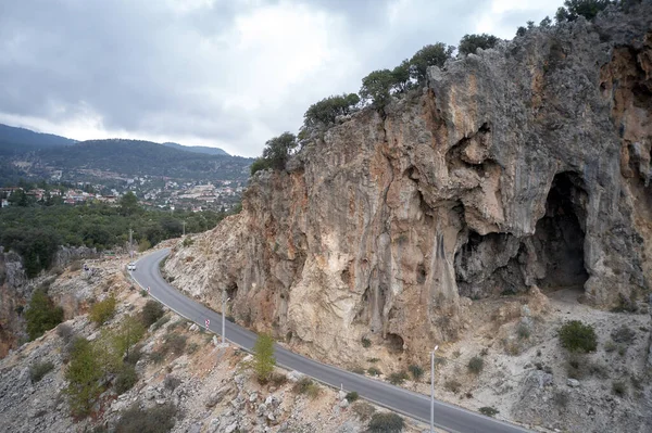 Road under high cliff in the mountains.