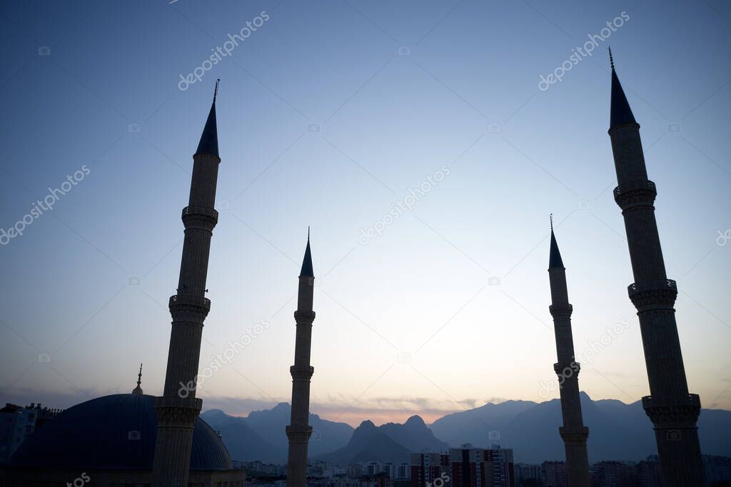 Four minarets against a sunset sky.