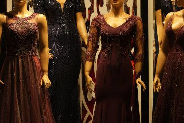 Moda butiğinde mankenler üzerinde uzun gece elbiseleri.