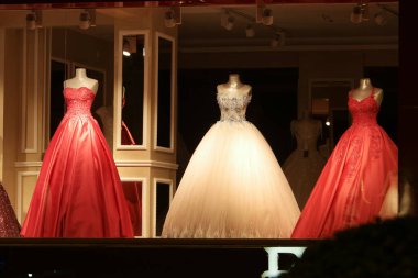 Kırmızı beyaz parti elbisesi giyen üç manken..