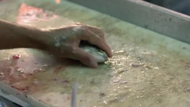 Mains mâles nettoyant le poisson argenté avec un couteau. — Video