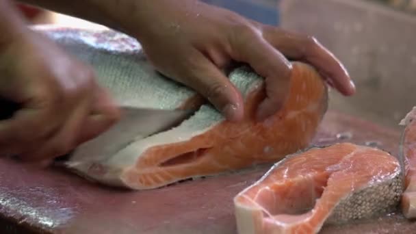 Nahaufnahme eines Mannes, der Fisch auf Schneidebrett schneidet. — Stockvideo