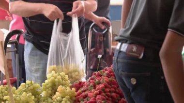 Meyve reyonundan üzüm alan adam..