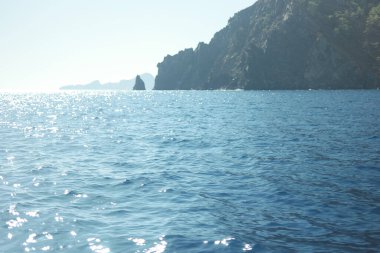 Rocky cliff, mavi deniz ve gökyüzü bir yaz gününde.
