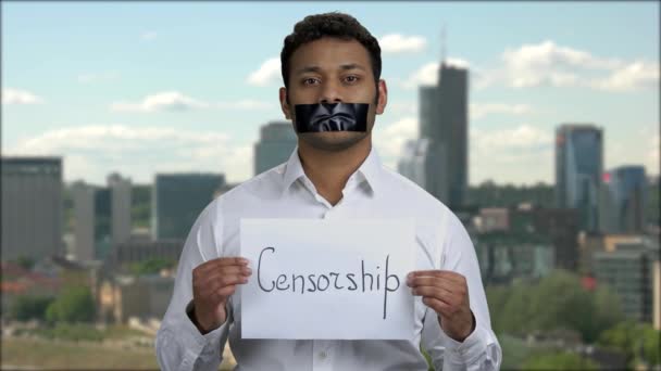 Indian man with taped mouth on cityscape background. — Stock Video