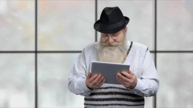 Kıdemli adam tablet bilgisayarla konuşuyor.