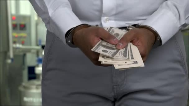 Gros plan homme d'affaires menotté tenant des billets de cent dollars. — Video