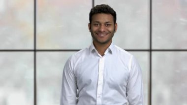 Genç başarılı iş adamı kameraya bakıyor..