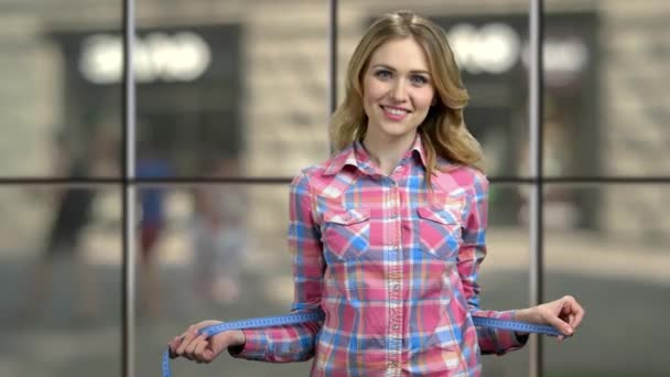 Happy woman with measuring tape looking at camera. — Stock Video