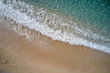 Tropikal sahilde su sıçratan deniz dalgalarının en üst görüntüsü.