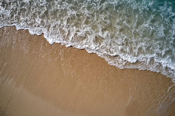 Costa arenosa amarela com ondas oceânicas espumosas. — Fotografia de Stock