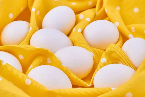 Huevos blancos de cerca sobre un paño de tela amarilla. — Foto de Stock