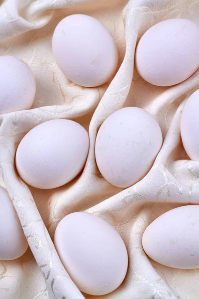 Närbild vita ägg på en rynkig gardin. — Stockfoto
