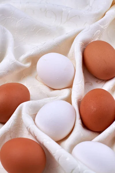 Vita och bruna ägg på en rynkig handduk. — Stockfoto