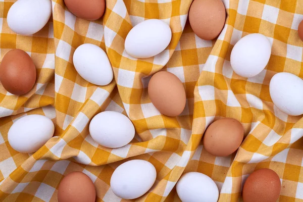 Ovanifrån bruna och vita ägg på en textilduk. — Stockfoto