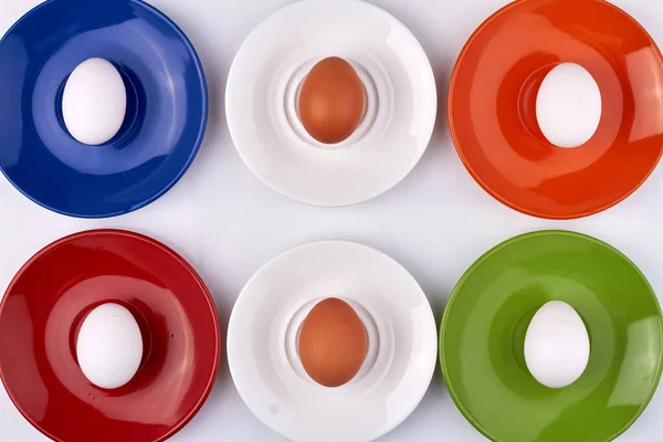 Samenstelling van eieren op gekleurde borden. — Stockfoto