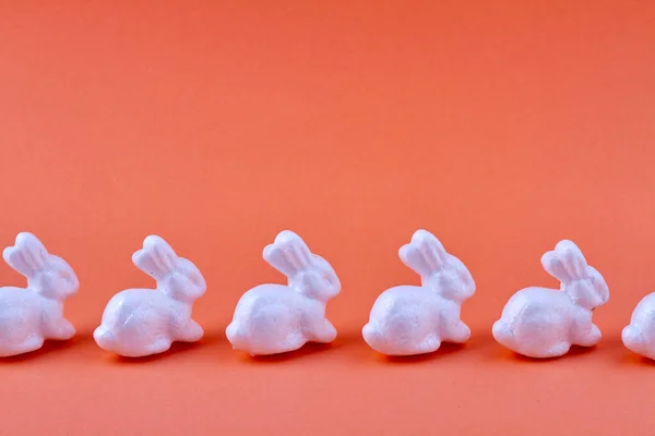 Fila de conejos de cerámica sobre fondo naranja. — Foto de Stock
