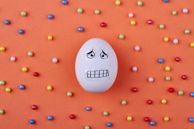 Yüzünde korku ifadesi olan tavuk yumurtası.