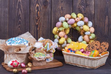 Renkli yumurtalı Paskalya pastaları ve koyu ahşap arka planda söğüt dalı..