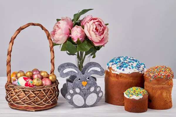 Blumenvase mit Häschen mit Ostereiern und Kuchen. — Stockfoto