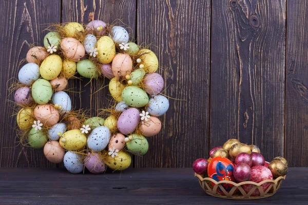 Pile of colored decorative eggs on dark wood. — Stock Photo, Image