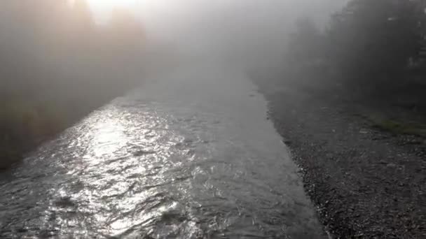 Rivière qui coule à travers le village de montagne dans un matin brumeux. — Video