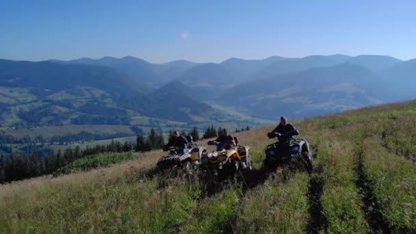ATV riders on grassy mountain hill in summer. — Vídeo de stock