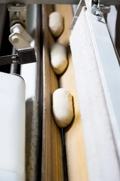 Massa de pão correndo na correia transportadora. Produção alimentar. — Fotografia de Stock