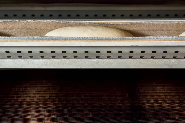 Produzione di prodotti da forno in fabbrica industriale. Pasta cruda presso attrezzature da forno. — Foto Stock