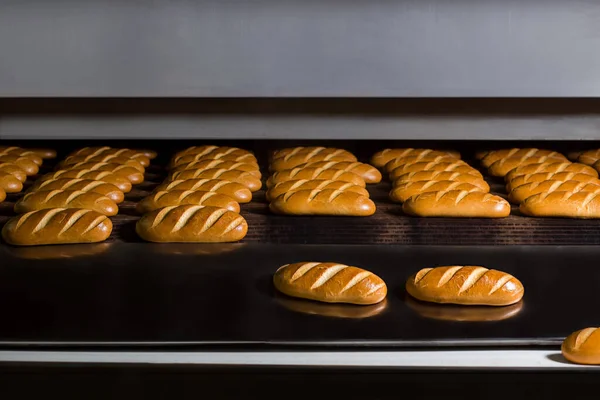 Baguettes baking in industrial oven. Food production. — Foto de Stock